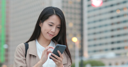 Woman look at smart phone at outdoorの写真素材