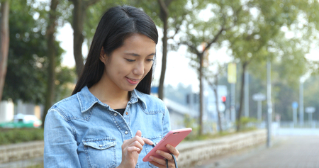 Woman use of mobile phone in cityの写真素材