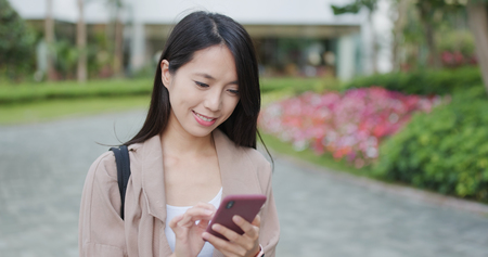 Young woman work on cellphone at outdoorの写真素材