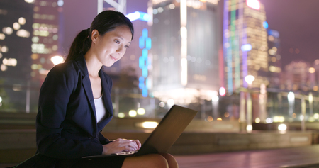 Businesswoman working laptop computer at nightの写真素材