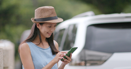 Travel woman checking the destination on cellphone during the road tripの写真素材