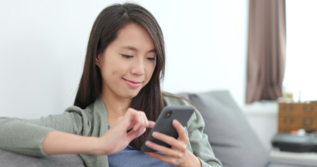 Housewife using smart phone at homeの写真素材
