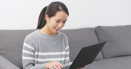 Woman working on notebook computer at homeの写真素材