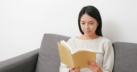 Woman reading book at homeの写真素材