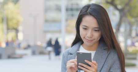Business woman using smart phone at streetの写真素材