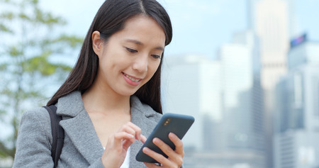 Woman use of mobile phone in cityの写真素材