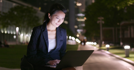 Businesswoman use of tablet computer at outdoor in the eveningの写真素材