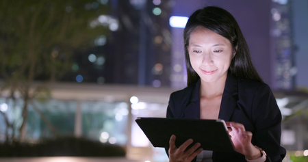 Business woman use of tablet computer at nightの写真素材