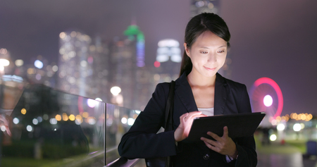 Asian business woman use of tablet computer at nightの写真素材