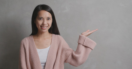 Woman showing open palm over grey backgroundの写真素材