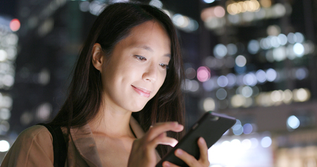 Woman sending text message on mobile phoneの写真素材