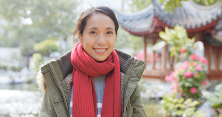 Woman wearing red scarf in the parkの写真素材