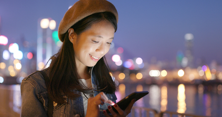 Woman use of mobile phone at nightの写真素材