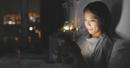 Woman use of smart phone at nightの写真素材