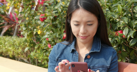 Woman use of mobile phone at outdoor parkの写真素材