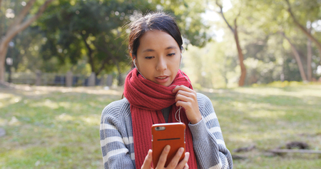 Woman talk to smart phone at parkの写真素材