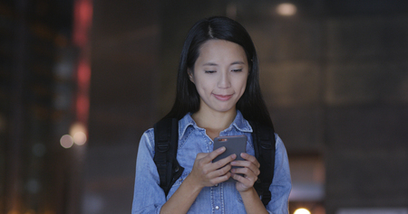 Woman use of mobile phone in city at nightの写真素材
