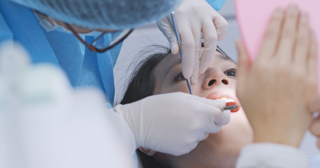 Woman checking on her teeth in dental officeの写真素材