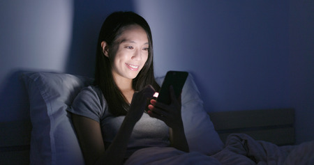 Woman use of mobile phone at nightの写真素材