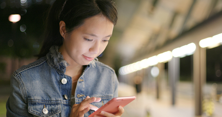 Woman use of smart phone at nightの写真素材