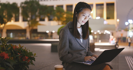 Businesswoman use of notebook computer at nightの写真素材