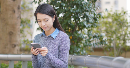 Woman use of smart phone at outdoorの写真素材