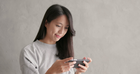 Woman playing on mobile phoneの写真素材