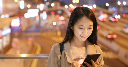 Business Woman use of cellphone in city at nightの写真素材