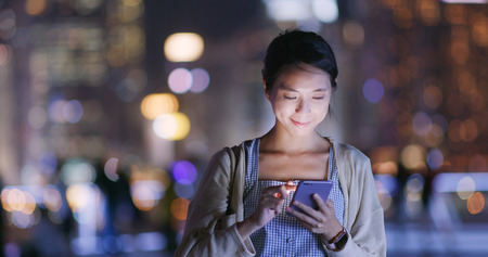 Woman use of mobile phone at nightの写真素材