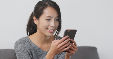 Woman use of smart phone at homeの写真素材