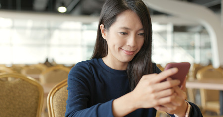 Woman using mobile phone at restaurantの写真素材