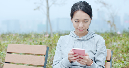 Woman working on cellphone in cityの写真素材
