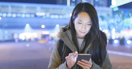 Woman using mobile phone at nightの写真素材