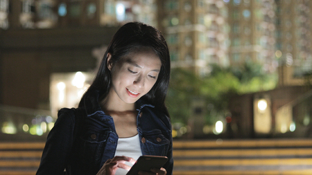 Woman using cellphone in cityの写真素材