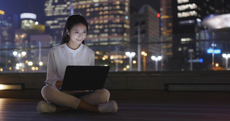Business woman working with laptop at nightの写真素材
