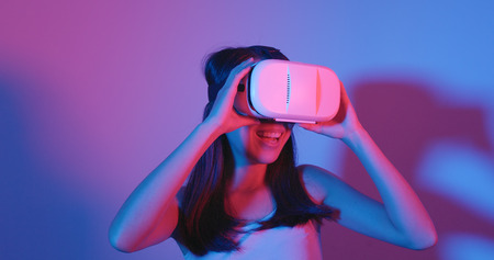 Woman watching VR with red and blue lightの写真素材