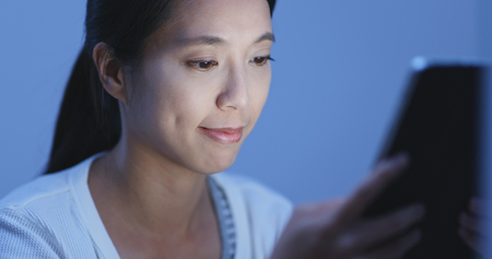 Woman watching on tablet at nightの写真素材