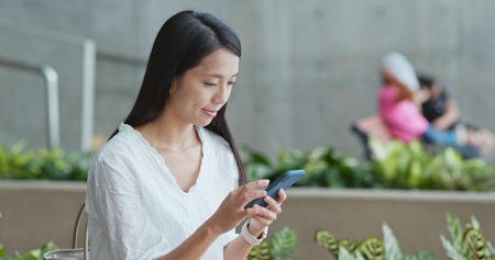Woman using cellphone in campusの写真素材