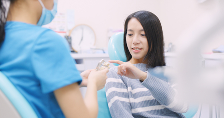 Doctor dentist explain the implant of teeth to patient in dental clinicの写真素材