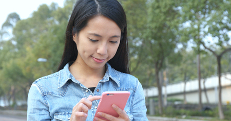Woman using mobile phone at outdoorの写真素材