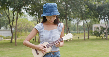 Woman playing a song with ukuleleの写真素材
