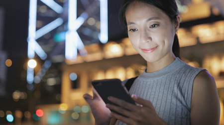 Woman use of mobile phone in cityの写真素材