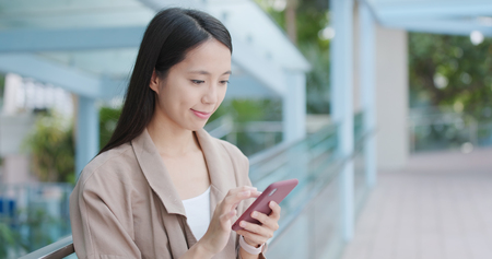 Woman working on cellphone at outdoorの写真素材