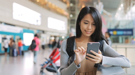 Young Woman using mobile phone in stationの写真素材