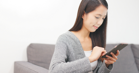 Woman use of mobile phone at homeの写真素材