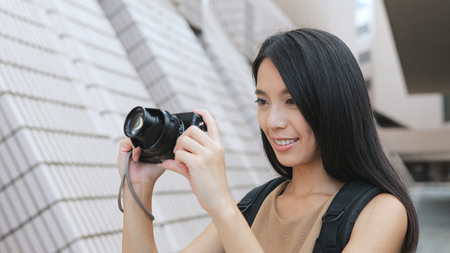 Young Woman taking photo with digital cameraの写真素材