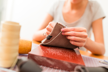 Woman making leather craft at homeの写真素材