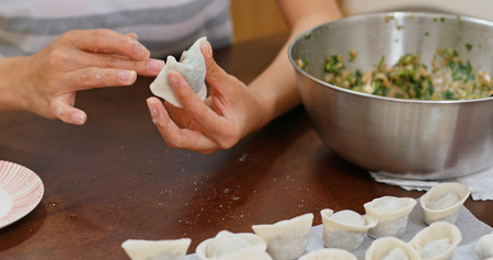 Woman making chinese meat dumpling at homeの写真素材