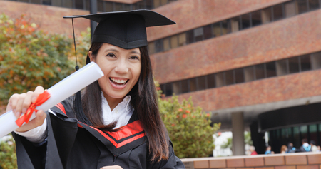 Excited Woman with graduation gownの写真素材