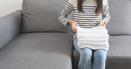 Housewife folding white towelsの写真素材